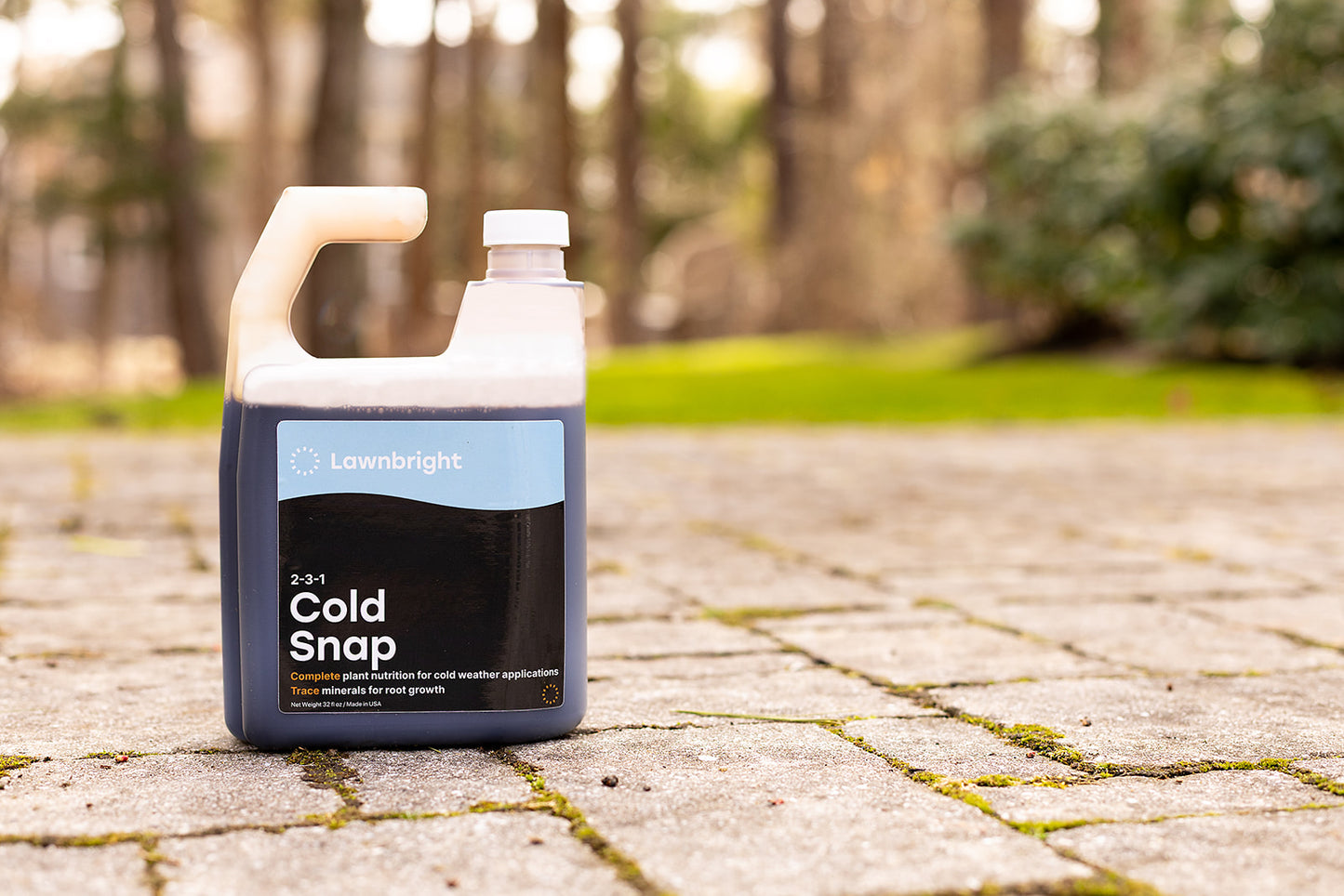 Lawnright Cold Snap product bottle on a stone path with trees in the background
