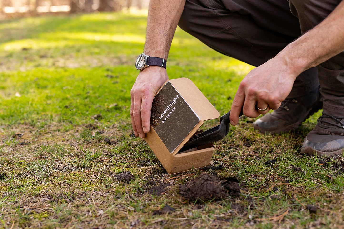 A man scoops soil into a soil test kit.