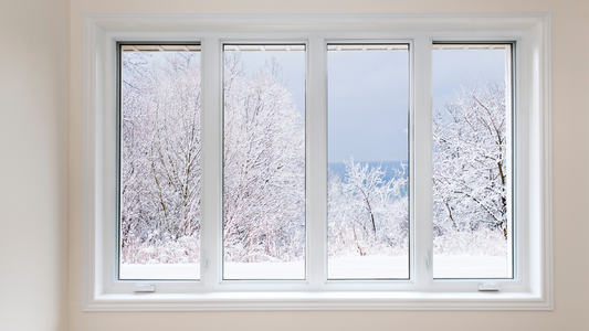 A picture window overlooking a backyard full of snow.